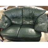 A modern green leather 2 seater settee with removable cushions.