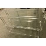 A modern Perspex shelving unit with glass shelves.