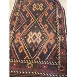 A ethnic patterned heavy cotton rug in natural brown and red shades.