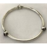 A 925 silver bangle with 3 bezel set garnet cabochons.