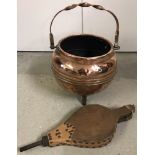 A vintage brass cauldron shaped coal bucket with tripod legs and twist design handle.