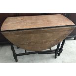 A vintage dark wood drop leaf, gate leg table with turned detail to legs.