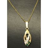 A 9ct gold pendant set with 2 emeralds & 2 small diamonds.