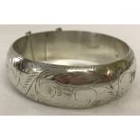 Silver hinged bangle with decorative engraving. Approx. 2cm deep.