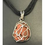 A contemporary design pendant made from natural coral decorated with silver.