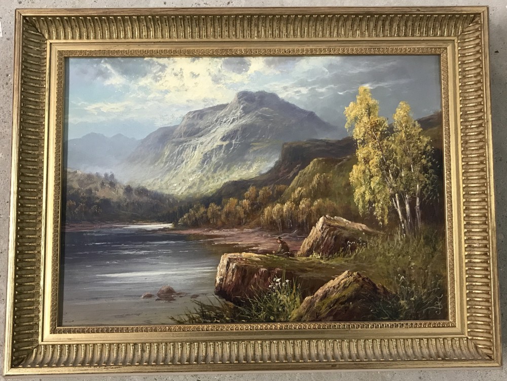 Gilt framed oil on canvas of a landscape with a fisherman in the foreground.