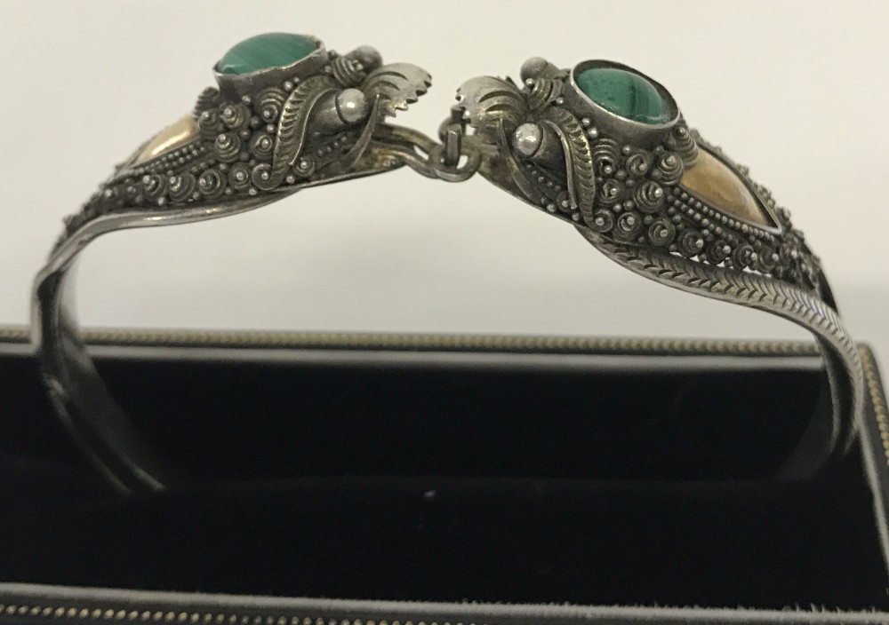 Ornate silver bangle set with malachite in decorative mounts.