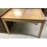 A modern light wood draw leaf extending dining table.