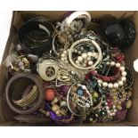 A box of assorted costume jewellery mostly beads and bangles.