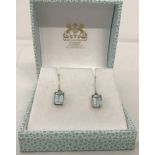 A pair of 9ct gold and square cut blue topaz drop earrings.