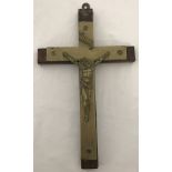A vintage brass crucifix on wall hanging wooden mount.