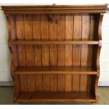 A set of stained pine wall hanging shelves.