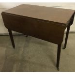 A vintage mahogany drop leaf table with tapered legs, spade feet and castors.