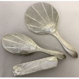 An Art Deco silver covered dressing table set comprising, 2 brushes and a hand mirror.