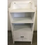 A modern white wood bathroom unit with small 2 door cupboard, 3 shelves and shaped top.