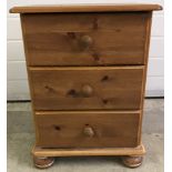 A small modern pine 3 drawer bedside cabinet.