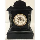 A heavy black slate and marble mantel clock with enamelled skeleton detail to dial.