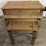 A modern pine corona style nest of 3 tables with cut out design to table tops.