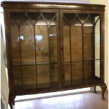 A vintage feather banded 2 door glass display cabinet with cabriole style legs.