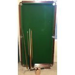 A vintage slate bed billiard table with green baize.