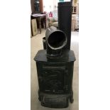 A vintage cast iron L. Lange & Co wood burner painted green.