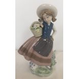 A retired Lladro porcelain figurine of a girl holding a basket.