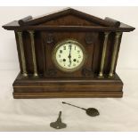 A vintage mahogany cased mantle clock with brass column detail.