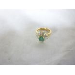 A 14ct gold dress ring set emerald flank