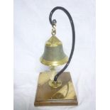 An unusual brass hanging table bell mounted on a wood base with plaques "Eritrean Railways Asmara"