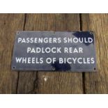 An enamelled sign "PASSENGERS SHOULD PADLOCK REAR WHEELS OF BICYCLES". 30.5 x 15cm