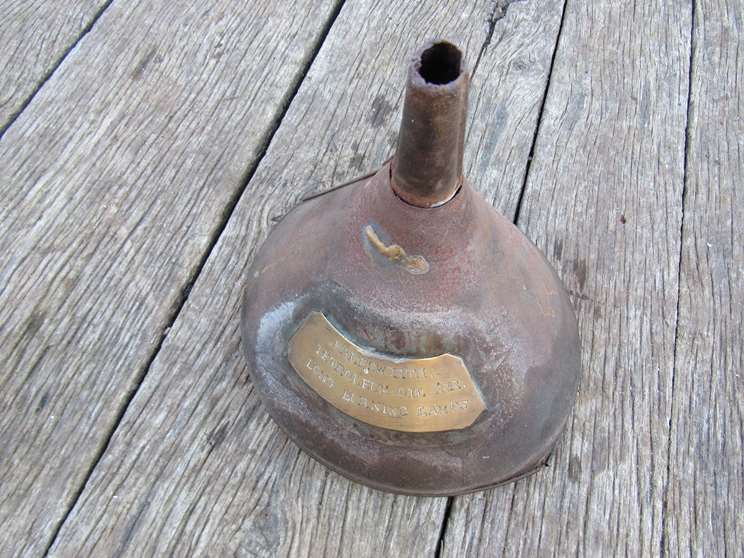 An oil funnel bearing a brass plaque inscribed "Halesworth Petroleum Oil" for long burning lamps"