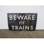 An enamel railway sign "BEWARE OF TRAINS", colour faded