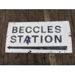 An enamel BECCLES STATION sign with arrow pointing to the left, black lettering on white background