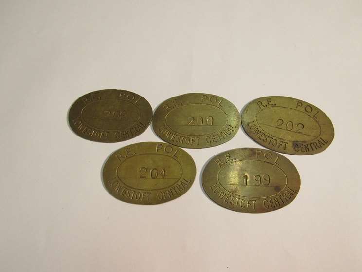 Five brass railway paychecks stamped POL (Petroleum, Oils and Lubricants/Police)