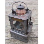 A railway signal lamp interior with reservoir and brass burner, stamped "SAXMUNDHAM"