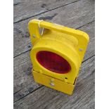 A modern yellow plastic cased battery operated permanent way railman's lamp with two red aspects