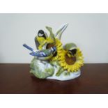 A Meissen marked porcelain figural group of Blue Tits and Great Tits on sunflower heads,