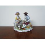 A Sitzendorf porcelain figural group "lady and gentleman making a garland of flowers",