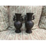 A pair of bronze Oriental vases with mythical beast handles