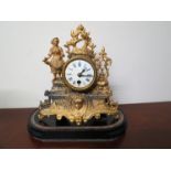 A late 19th Century French gilt ormolu clock with circular white enamel face,