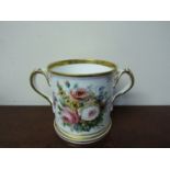 A Victorian twin handled porcelain presentation cup handpainted with floral spray inscribed in gilt