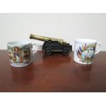 A brass canon and two commemorative mugs relating to WWI