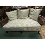 Circa 1900 a Bergere two seater sofa on carved outswept feet