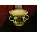 AMENDED DESCRIPTION: - A Paul Young pottery slipware pot with multiple handles and leaf design