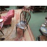 Four near matching elm seated Windsor style dining chairs with wheel/roundel backs,