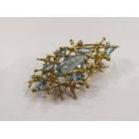 An 18ct gold branch form modern design brooch set with lozenge blue stones and diamonds