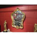 A carved gilt shield framed shape mirror