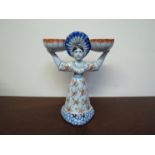 A 19th Century Dutch delft female salt seller figure with two bowls held aloft,