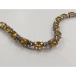 A silver bracelet set with seventeen oval citrine stones