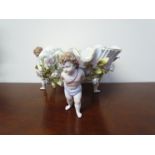 A Continental porcelain basket held aloft by three putti,